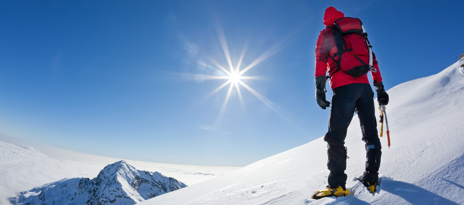 Mountaineer reaches the top of mountain.